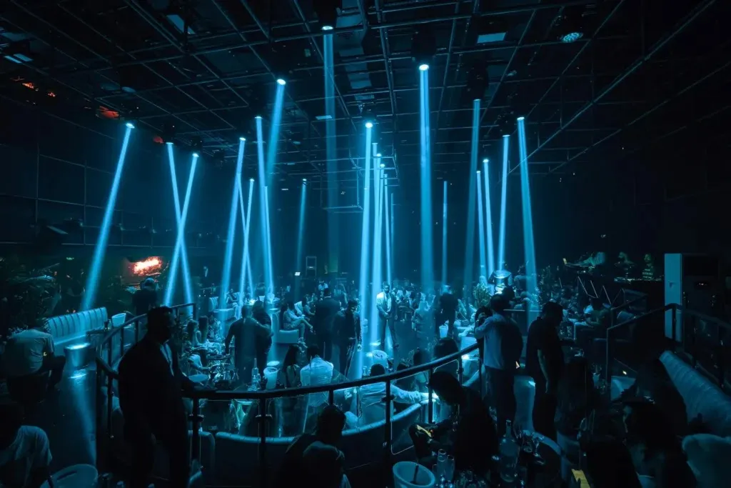 Blue vertical light beams over the main room, with VIP seating along the edge