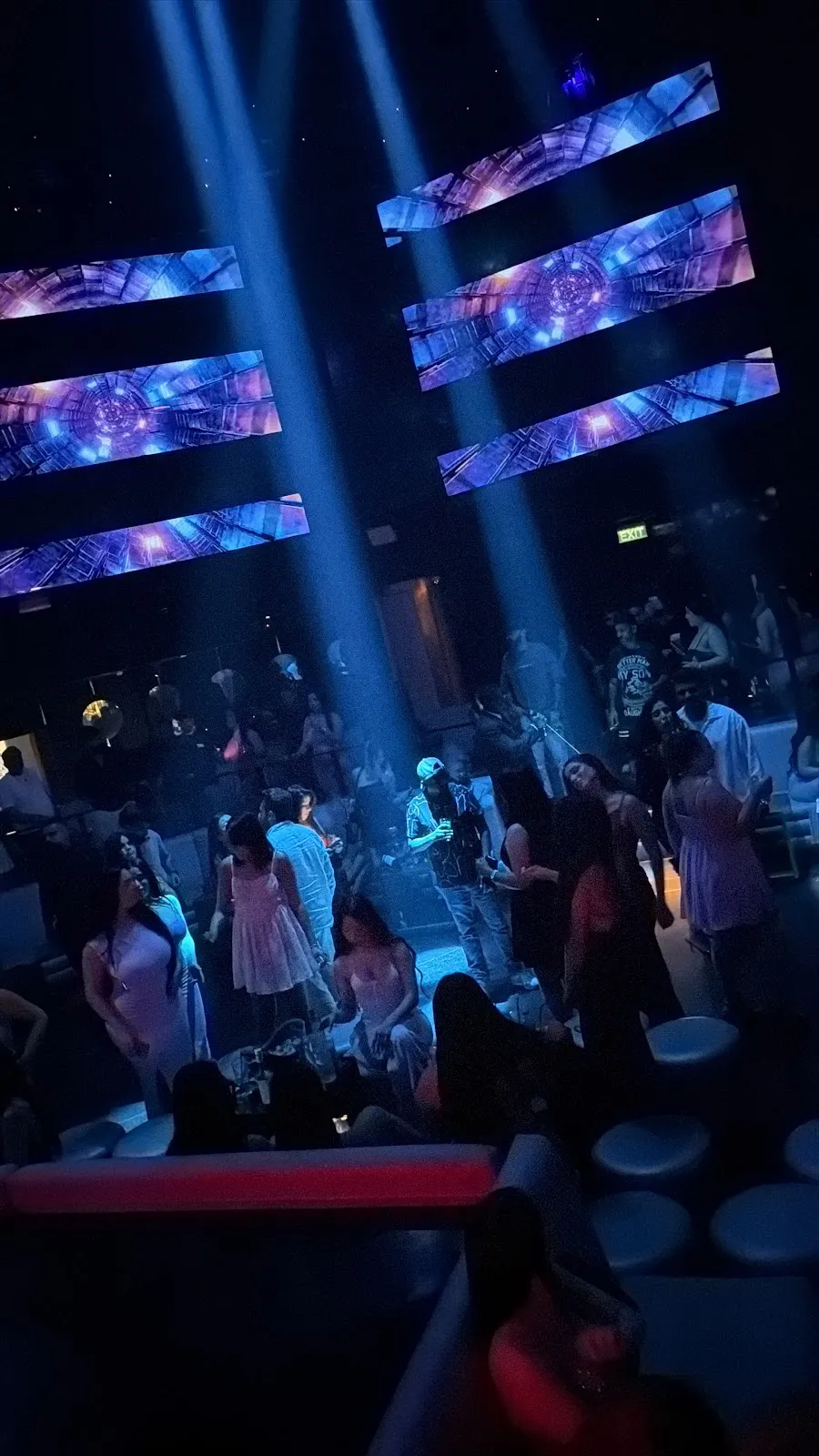 Guests on the dance floor beneath geometric LED panels